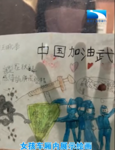 女孩车厢内展示绘画 隔窗为武汉加油！