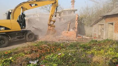 市“两违”整治办对违法占用农田养牛棚实施强拆 