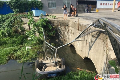 一轿车失控撞开护栏冲入河渠