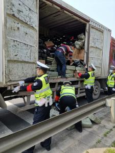 货物洒落公路旁 民警及时把忙帮