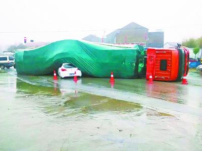 大卡车雨中侧翻压瘪轿车 3人钻出车村民帮忙清理现场