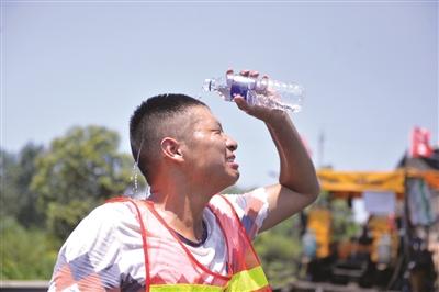 高温天气筑路工摊铺沥青体感温度90度 每天喝6桶水