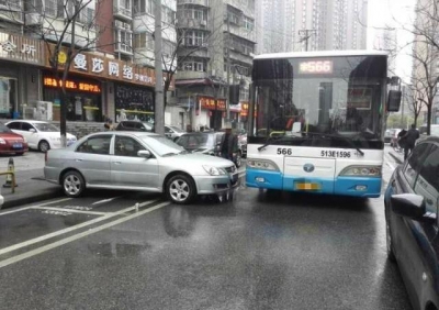 私家车路口违停卡死公交车 8名男子合力将违停车抬走