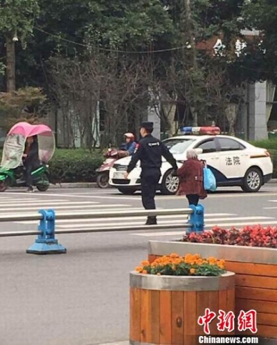22岁警察牵80岁老婆婆过街 被赞“最暖牵手”