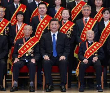 张富清坐在了习近平总书记身边