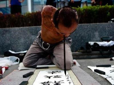 14年咬坏上百支毛笔 双臂截肢男子用嘴写书法养家